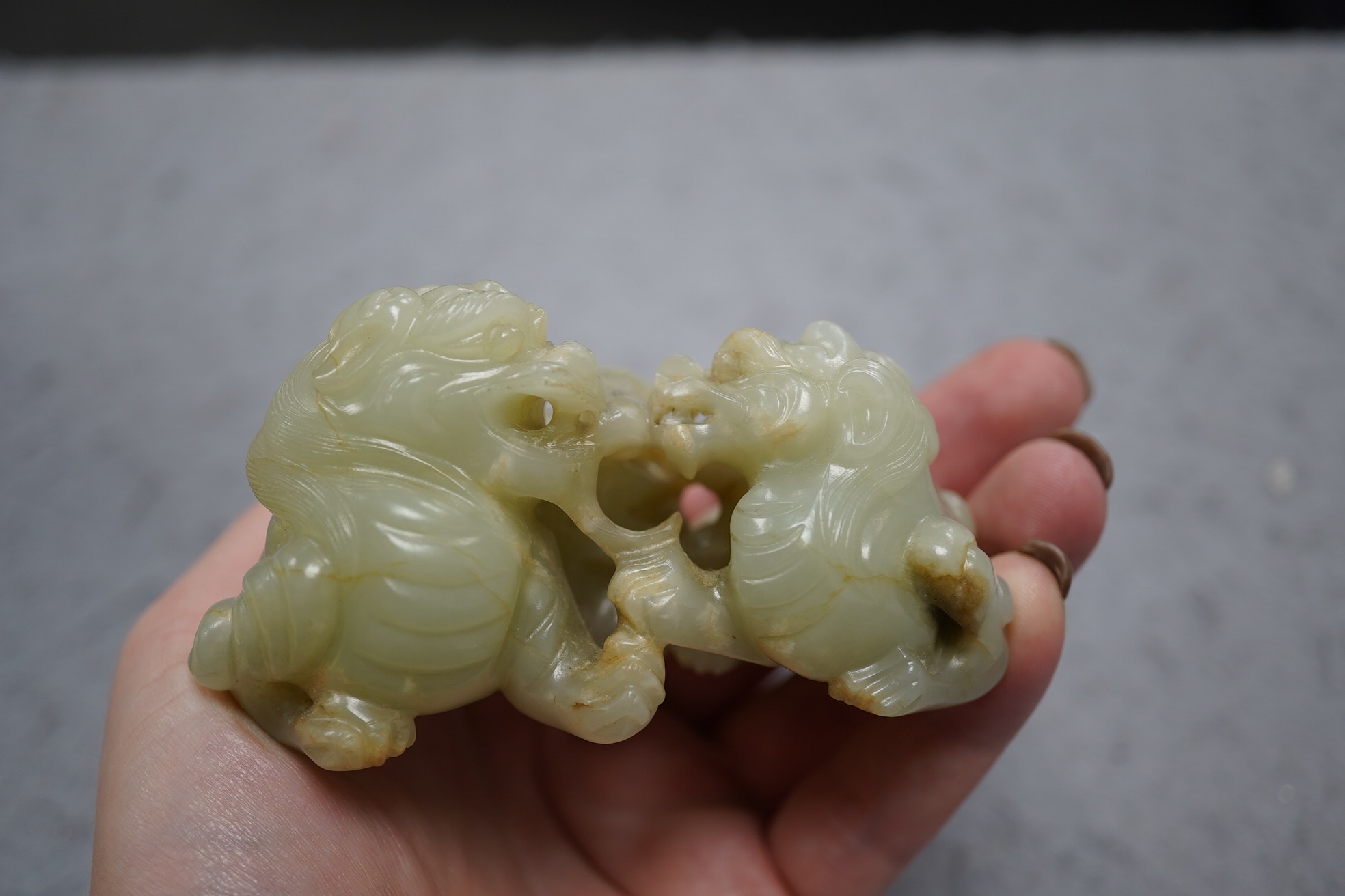 A Chinese celadon and russet jade group of two lion-dogs, 19th century